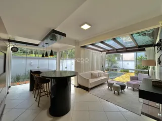 Sala de estar com vista para o jardim através de grandes janelas.
