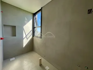 Ambiente interno com paredes cinzas e uma janela grande mostrando a vista externa.