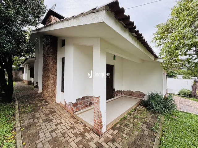 Fachada de uma casa em Lajeado, Brasil, com paredes brancas e detalhes em tijolo aparente.