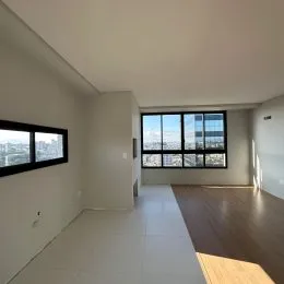Sala de estar com grande janela oferecendo vista da cidade.