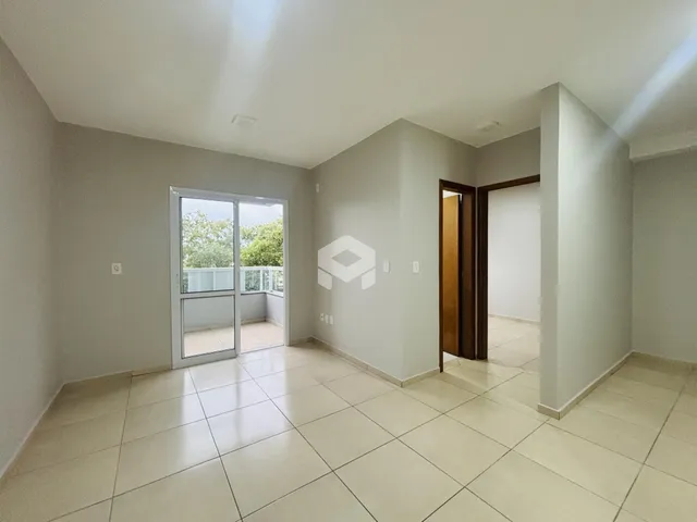 Interior de uma sala com piso de cerâmica e porta de vidro abrindo para uma área externa.