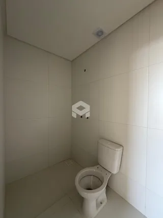 Foto de um banheiro com revestimento branco e vaso sanitário.