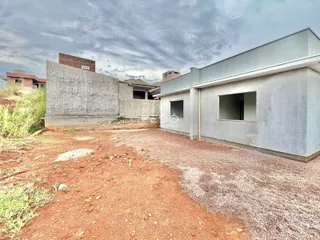 Vista externa de uma construção em Lajeado, Brasil, com paredes de concreto expostas e terreno irregular.