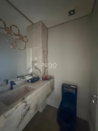 Vista de uma bancada de pia com acabamento em mármore claro em uma propriedade.