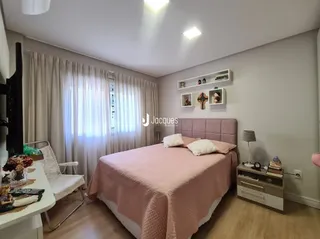 Quarto com cama e cortinas em um ambiente claro.
