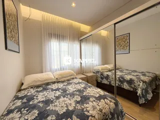 Quarto com duas camas e cortinas brancas.