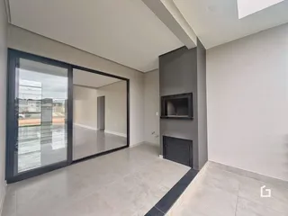 Sala de estar com portas de vidro grandes e piso claro.
