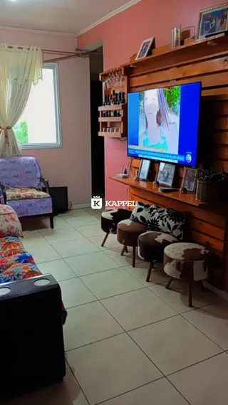 Esta é uma sala de estar com sofá e uma televisão montada na parede.