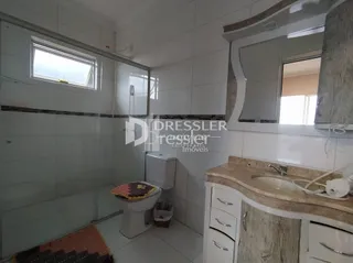 Interior de um banheiro com revestimento cerâmico branco.