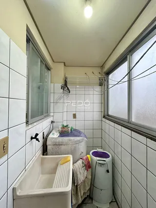 Foto interna de um banheiro com revestimento de azulejos brancos.
