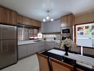 Foto de uma cozinha com armários de madeira e eletrodomésticos em aço inoxidável.