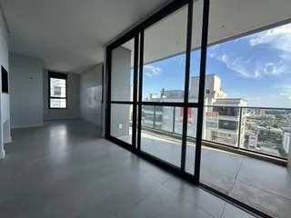 Uma sala de estar moderna com grandes janelas que oferecem uma vista da cidade.