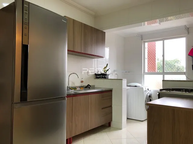 Cozinha moderna com armários de madeira e eletrodomésticos de aço inoxidável.