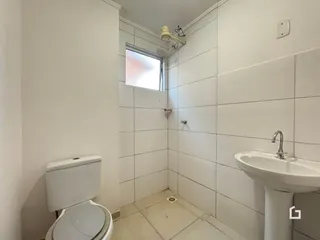 Banheiro com piso de cerâmica e paredes brancas em Lajeado.