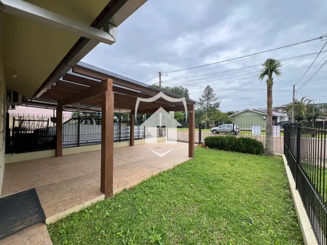 Vista da fachada de uma casa com área externa e gramado.