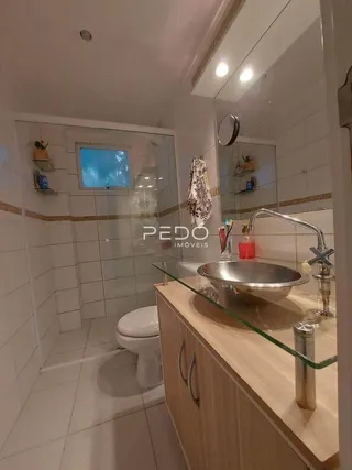 Foto de um banheiro com revestimento cerâmico e janela.