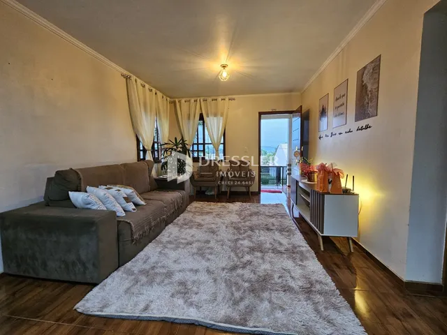 Sala de estar com sofá e piso de madeira em um imóvel no Brasil.