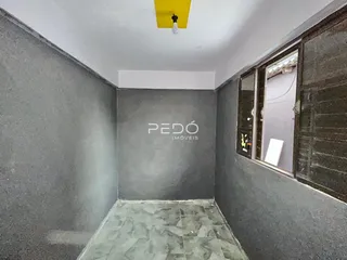 Hall de entrada com piso de azulejos claros e parede cinza na propriedade.