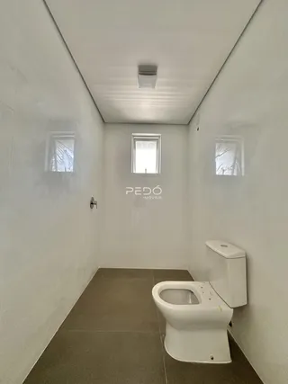 Foto de um banheiro com piso de cerâmica e janela em uma residência.