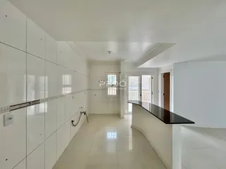 Corredor interno de uma residência com piso de cerâmica branca.