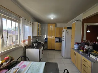 Imagem de uma cozinha com armários de madeira e janela em Lajeado.