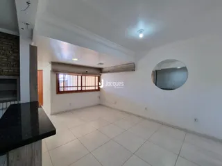 Sala de estar com piso de cerâmica e janela de madeira em um imóvel no Brasil.