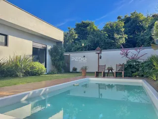 Vista da fachada de uma residência com piscina e jardim em Lajeado.