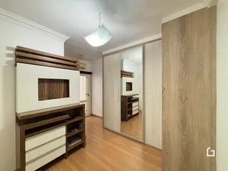 Sala de estar com lareira e piso de madeira clara.