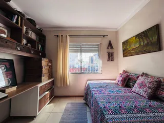 Quarto com estante de madeira e cama decorada em um imóvel no Brasil.