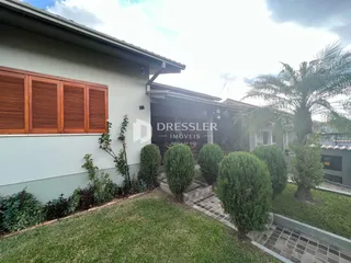 Fachada de uma residência com jardim e vegetação na Lajeado, Brasil.