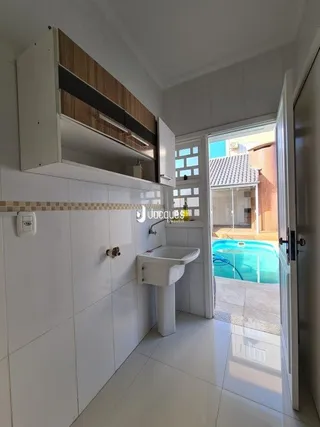 Parede interna com revestimento branco e piso de cerâmica em uma residência.