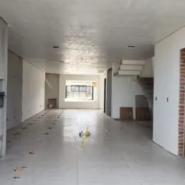 Hall de entrada com teto de textura clara e piso de concreto.