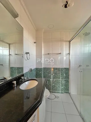 Foto de um banheiro com revestimento de azulejos verdes e brancos.