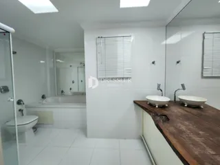 Foto de um banheiro com piso de cerâmica e bancada de madeira.