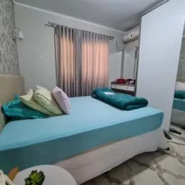 Quarto com cama e cortinas claras em um imóvel.