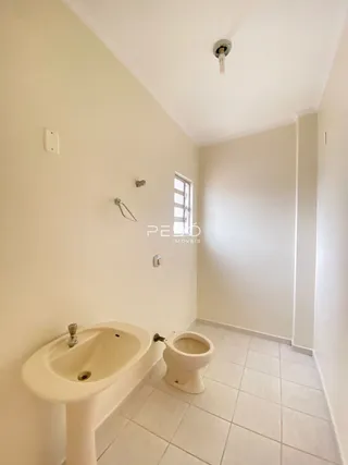Foto de um banheiro interno com pia e vaso sanitário brancos.