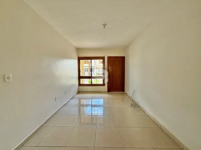 Hall de entrada com piso de cerâmica e paredes brancas.