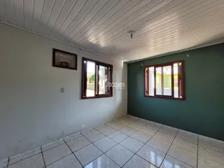 Interior de uma sala com piso de cerâmica e paredes brancas.