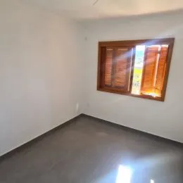 Foto de um cômodo interno com paredes brancas e piso cinza.