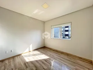 Ambiente interno com piso de madeira clara e paredes brancas.