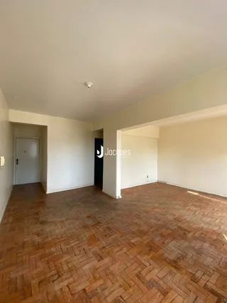 Interior de uma sala com piso de ladrilhos terrosos.