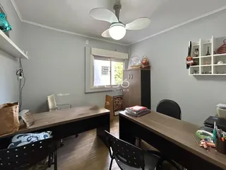 Ambiente interno de uma sala com piso de madeira e móveis de escritório.