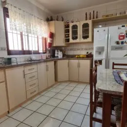 Foto interna de uma cozinha com armários e piso de cerâmica.