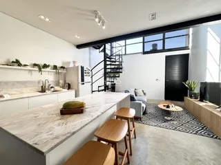 Interior de uma sala de estar e cozinha moderna com ilha de mármore.