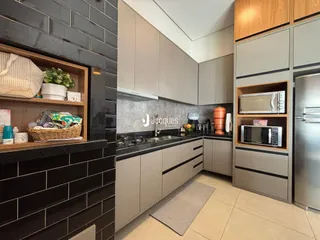 Cozinha moderna com armários cinzas e revestimento escuro em Lajeado.