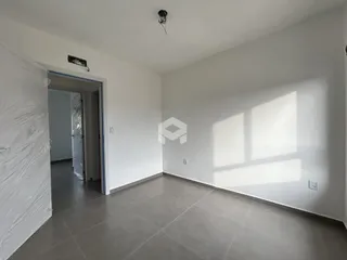 Hall de entrada com piso de cerâmica e paredes brancas.