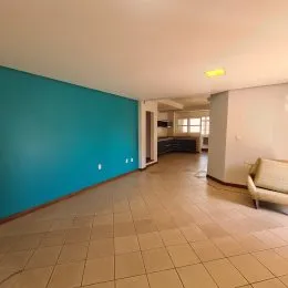 Vista de um corredor interno com paredes azuis e piso de cerâmica.
