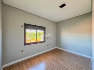 A sala apresenta piso de madeira e paredes em tom de cinza claro.