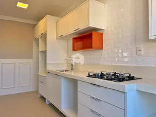 Cozinha moderna com armários brancos e revestimento branco.
