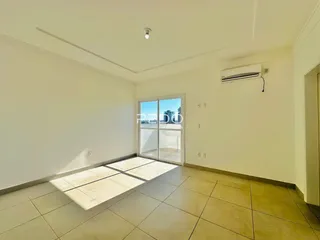 Sala ampla com piso de cerâmica e porta de vidro que dá acesso ao exterior.